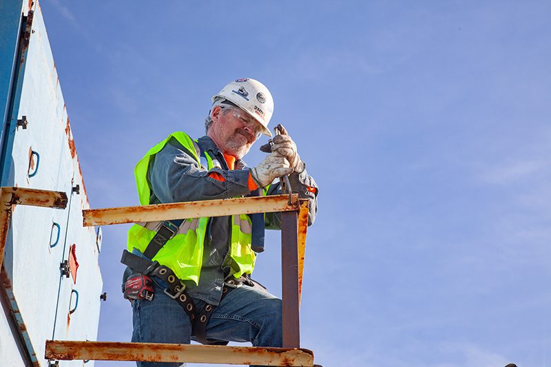 a construction worker putting on safety gloves